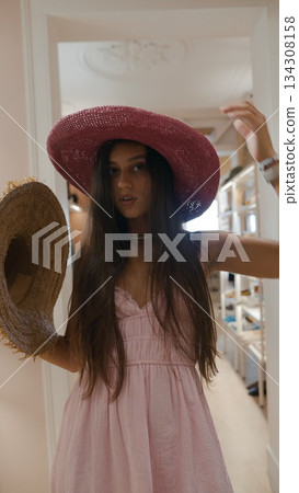 A Stylish Summer Vibes A Young Woman Wearing a Pink Hat and a Lovely Dress, Exuding Charm 134308158