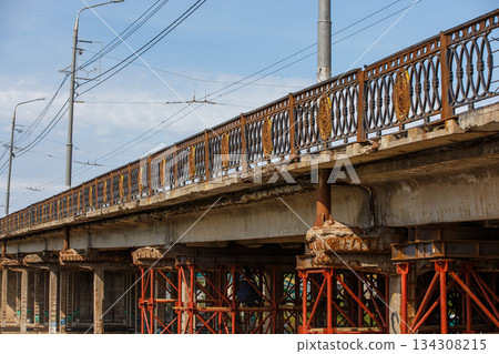 Adult working on urban bridge repair during daytime 134308215