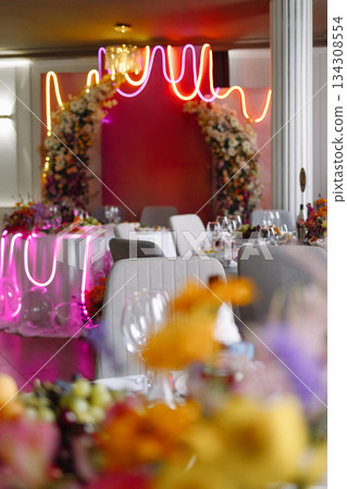 Festive event table with floral arches and neon lights Festive event table with floral arches and neon lights 134308554