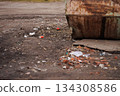 Scattered trash near rusty metal dumpster outdoors. Copy space. 134308586