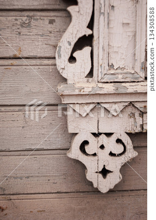 Carved wooden ornament on weathered house wall 134308588