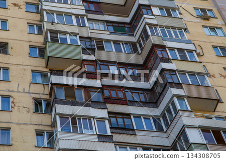 Weathered building with numerous balconies and windows in urban setting Weathered building with numerous balconies and windows in urban setting 134308705