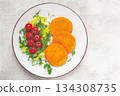 crispy fried fish cutlets, fish burgers, on a white plate, with fresh lettuce leaves, arugula and cherry tomatoes, homemade, no people, 134308735