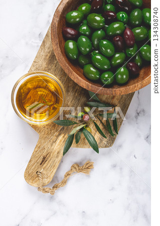 Chalkidiki olives, classic Greek green olives, in a bowl on a cutting board, top view, without people, Chalkidiki olives, classic Greek green olives, in a bowl on a cutting board, top view, without people, 134308740
