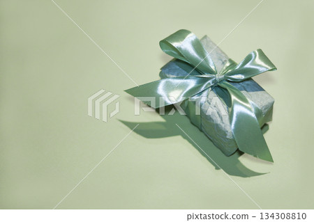 Stylish mint colored present with satin ribbon symbolizing celebration and care Stylish mint colored present with satin ribbon symbolizing celebration and care 134308810