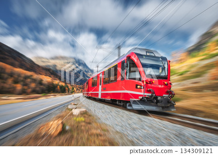 Red modern passenger train is moving on railway in swiss alps 134309121
