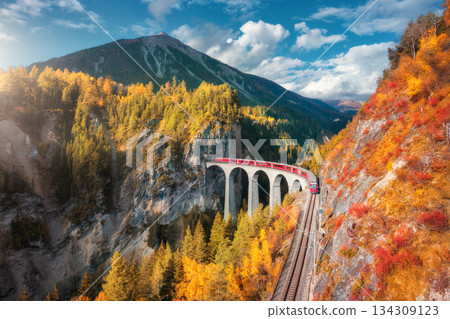 Aerial view of modern red train on Landwasser viaduct in autumn 134309123