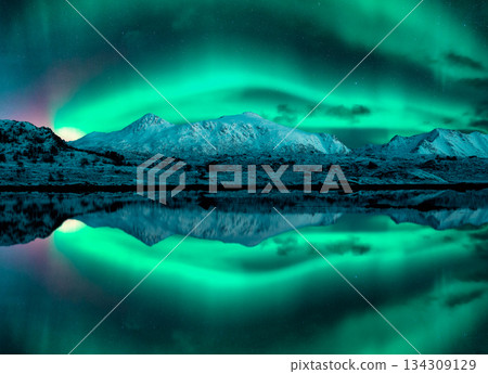 Aurora borealis over the snowy mountains, reflection in water 134309129