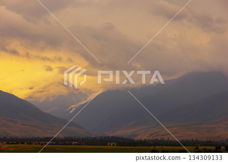 Dramatic sunset over mountains and village in valley 134309133