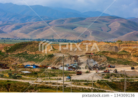 Heavy construction vehicles working at rugged quarry site in Kyrgyzstan Heavy construction vehicles working at rugged quarry site in Kyrgyzstan 134309136