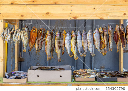 Dried smoked fish displayed in rustic outdoor market stall 134309798