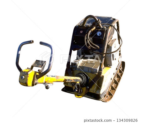 A realistic image of a yellow and black vibratory plate compactor with a steel handle 134309826