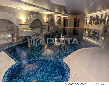 Home swimming pool with water in a light marble interior 134311272