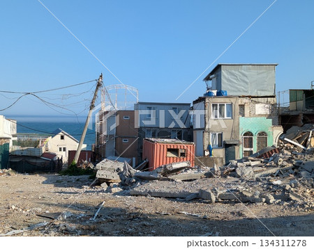 A dilapidated area with houses covered in construction debris near the sea A dilapidated area with houses covered in construction debris near the sea 134311278