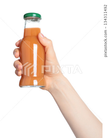 Hand holding a glass bottle filled with orange juice, isolated on transparent background. Suitable for food, drink, freshness, citrus, and healthy lifestyle projects 134311492