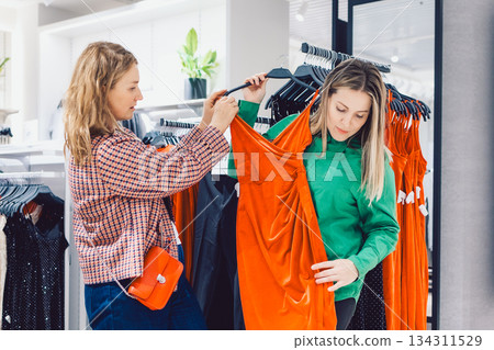 Two female friends are choosing clothes in store Two female friends are choosing clothes in store 134311529