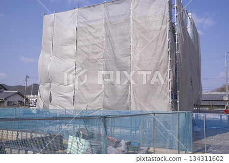 A house under construction covered in protective sheets 134311602