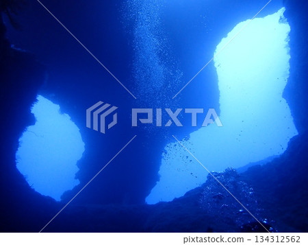 A view of light shining through a crevice in the rocks from inside an underwater cave A view of light shining through a crevice in the rocks from inside an underwater cave 134312562