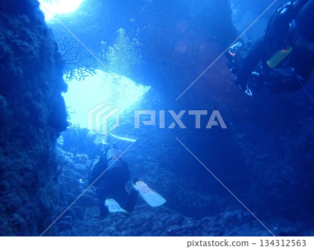 Diver swimming through an underwater cave 134312563