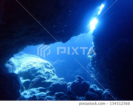 A view of light shining through a crevice in the rocks from inside an underwater cave A view of light shining through a crevice in the rocks from inside an underwater cave 134312568