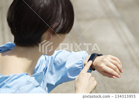 一位 40 多歲的女性在運動時使用智慧手錶 134313955
