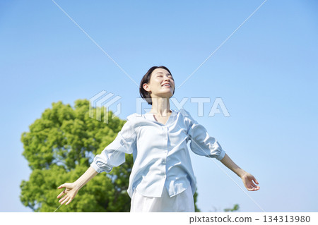 Woman taking a deep breath outdoors 134313980