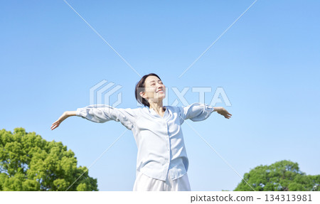 Woman taking a deep breath outdoors 134313981