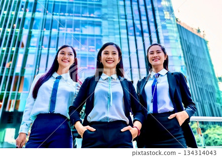 一名女員工站在一棟建築物前,背景是一棟建築物。 一名女員工站在一棟建築物前,背景是一棟建築物。 134314043