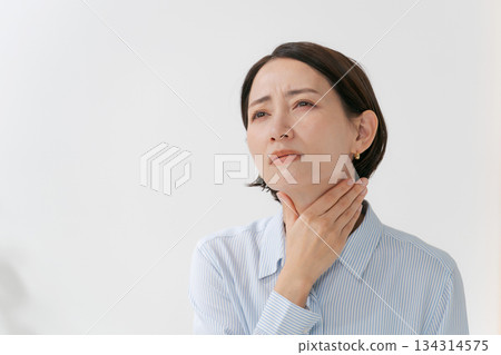 A woman complaining of neck and throat problems 134314575