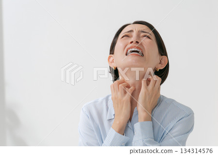 A woman complaining of neck and throat problems 134314576