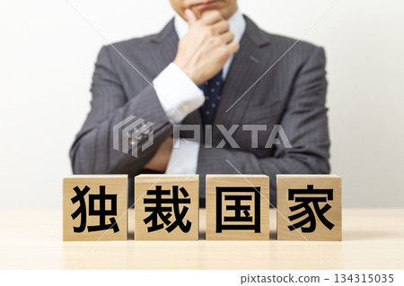 Blocks with the word "dictatorship" written on them and a businessman 134315035