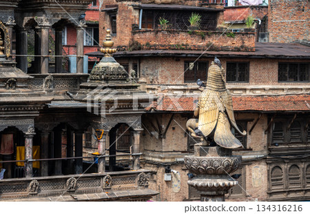 Rear view of the Garuda statue sitting on stone pillar in Patan Durbar Square, Nepal. Rear view of the Garuda statue sitting on stone pillar in Patan Durbar Square, Nepal. 134316216