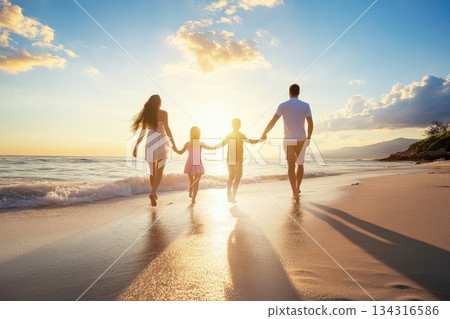 Joyful Family Walking Together Along Sandy Beach at Sunset with Reflection on Water 134316586