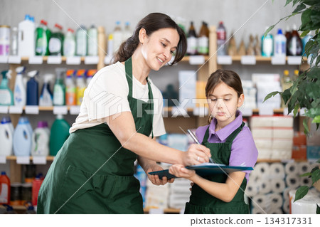 Woman seller and her daughter take inventory in store Woman seller and her daughter take inventory in store 134317331