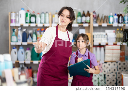 Woman seller and her daughter take inventory in store 134317398