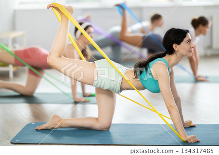 Group of women with working out with rubber bands on my knees in gym Group of women with working out with rubber bands on my knees in gym 134317485