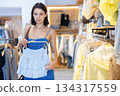 Young woman choosing clothes in a store in summer 134317559