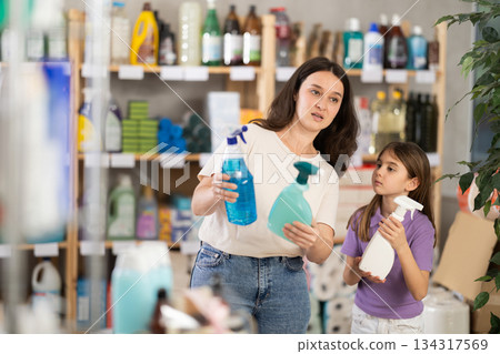 Woman with daughter choosing cleaning spray 134317569