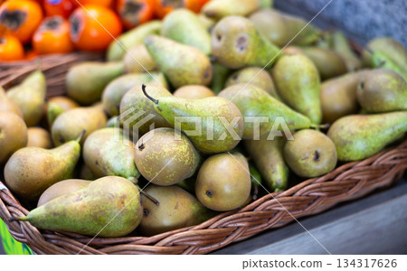 View of ripe pears in a wicker basket, put up for sale in store View of ripe pears in a wicker basket, put up for sale in store 134317626