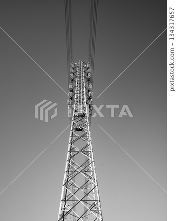 Power line tower looking up at the blue sky, monochrome 134317657