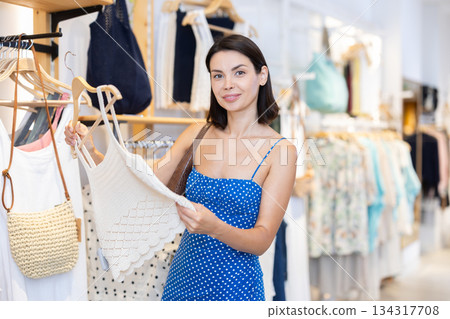 Young woman choosing clothes in a store in summer Young woman choosing clothes in a store in summer 134317708