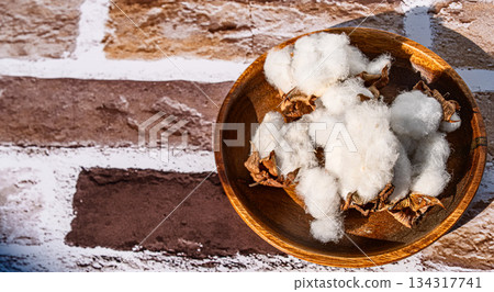 Cotton flowers on a wooden plate Cotton flowers on a wooden plate 134317741