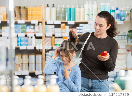 Woman checks daughter's hair on lice Woman checks daughter's hair on lice 134317859
