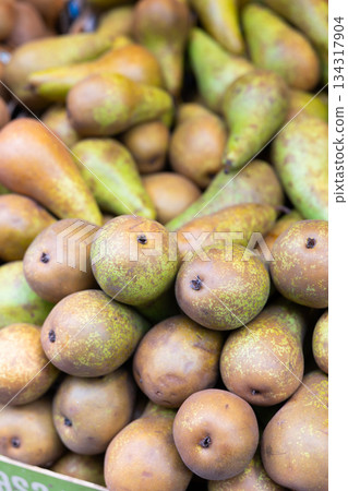 View of ripe pears in a wicker basket, put up for sale in store 134317904