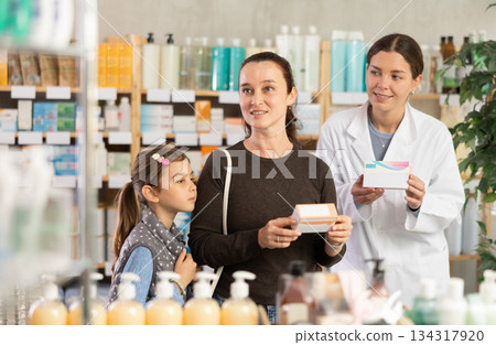 Positive mother with daughter choosing pills in drugstore Positive mother with daughter choosing pills in drugstore 134317920