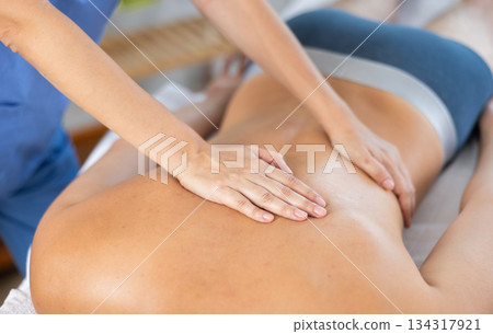 Masseuse doing back massage to young guy 134317921