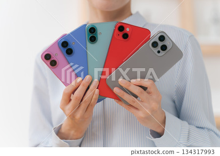 一位女士拿著各種顏色的智慧型手機殼 134317993