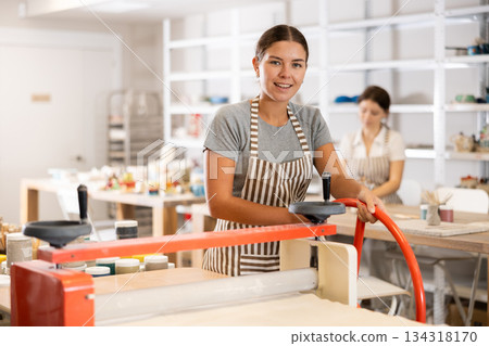 Young woman working on polymer clay rolling machine Young woman working on polymer clay rolling machine 134318170