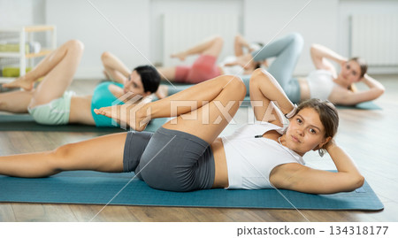 Young girl doing press exercise in pilates studio Young girl doing press exercise in pilates studio 134318177