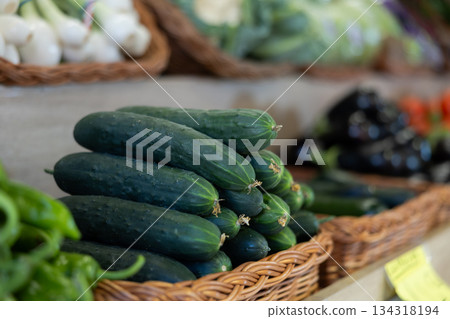 View of cucumbers in a wicker basket, put up for sale in store View of cucumbers in a wicker basket, put up for sale in store 134318194